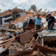 A couple react as they go through their destroyed mobile home following the passing of hurricane Laura in Lake Charles, Louisiana, on August 27, 2020. The same area is set to be hit by Hurricane Delta on Friday.
